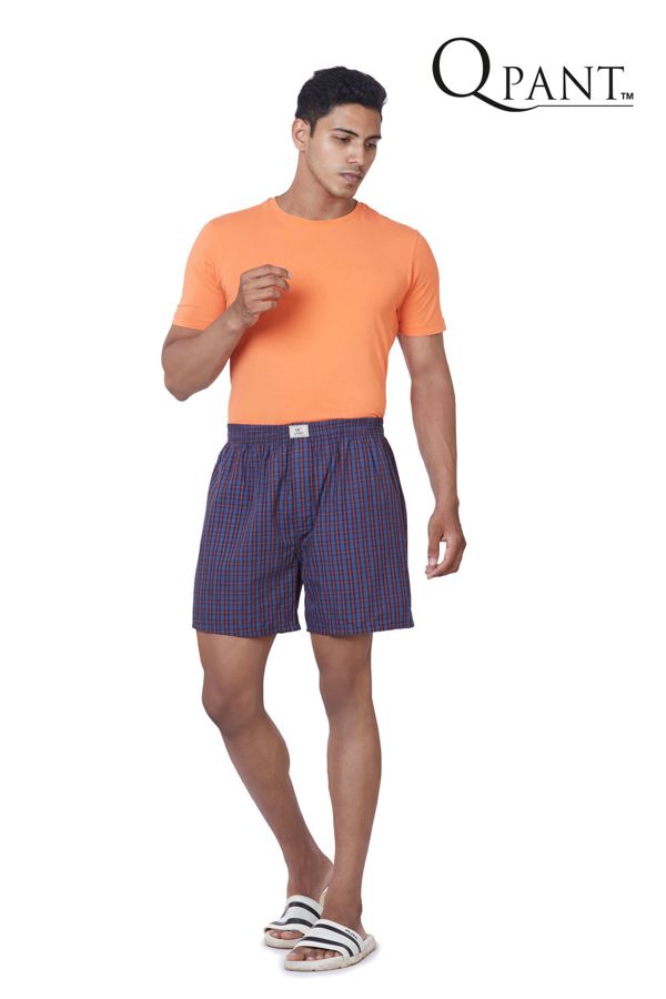 Model in navy check boxer shorts and orange tee