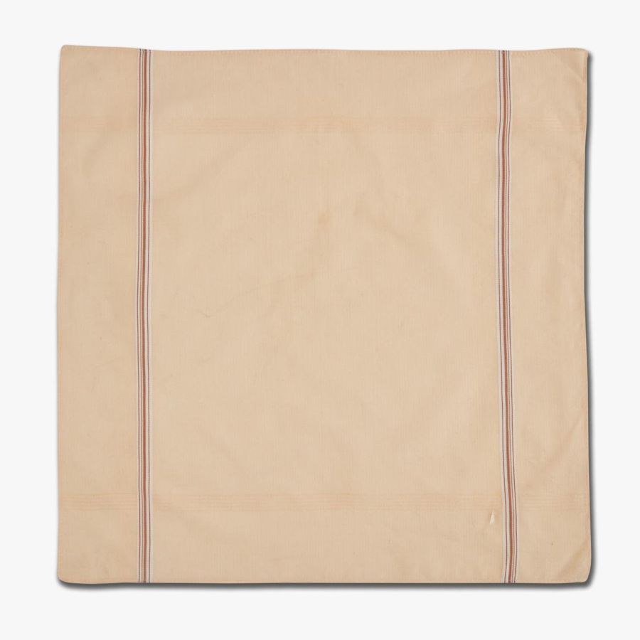 An unfolded peach handkerchief showing the border stripe